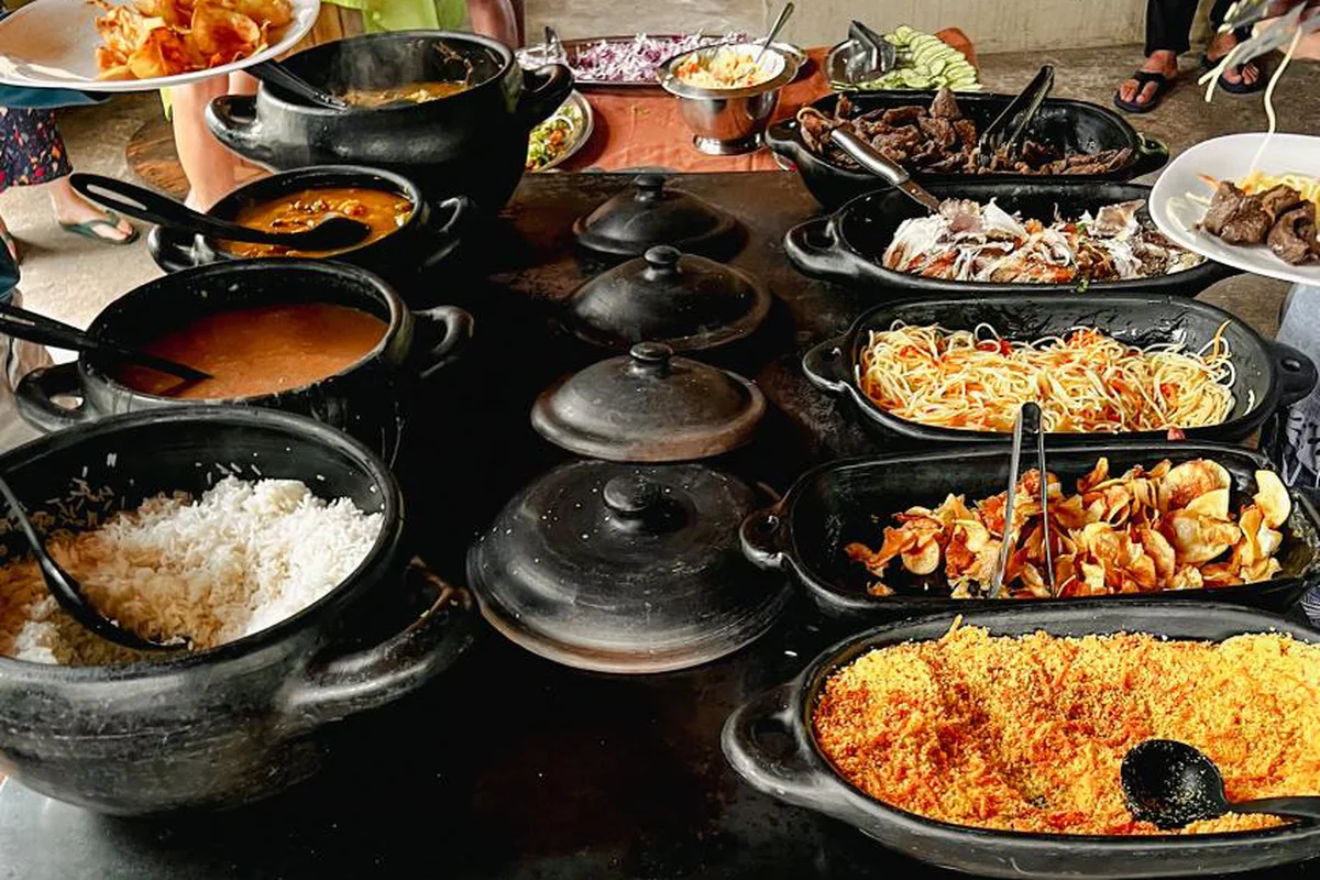 Panelas de barro com arroz, farofa, peixe e carne servidos numa mesa do Jalapão